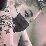 Фото тату на руке и плече девушки в черно-белом стиле, с акцентом на макияж и аксессуары.