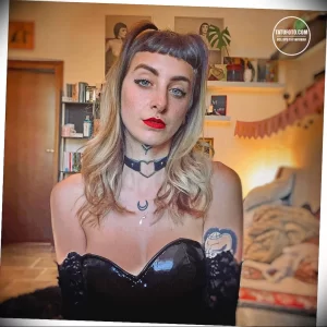 Фотография девушки с татуировками в виде луны, звезд и мистических символов на шее и ключице, выполненными в тонком и изящном стиле.