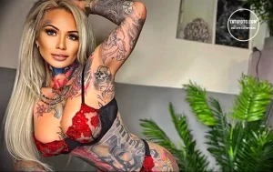 Фотография девушки, покрытой татуировками в различных стилях. На теле видны рисунки черепов, роз, надписей и других элементов.