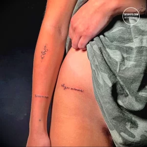 Фото тату на внутренней стороне предплечья: надпись на испанском 'Tu risa es magia' и небольшой символ, выполненные тонкими линиями.