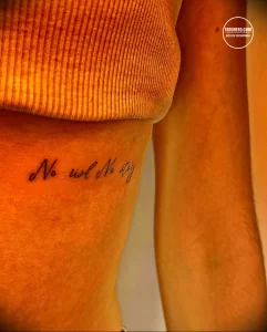 Фото тату: небольшая татуировка с надписью 'No risk No story' на руке девушки, выполненная тонкой линией.