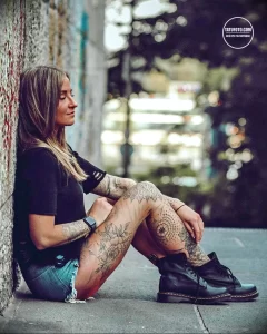 Фото тату на ногах и руках девушки, демонстрирующее цветочные и геометрические рисунки в ярких цветах. Видна детализация и насыщенность красок.