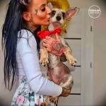 Фото татуировки на руке с изображением красной розы и надписи LOVE. Рисунок выполнен в ярких цветах и имеет четкие контуры.