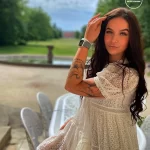 Фото тату на плече девушки: изображение птицы в полете, выполненное в черно-белой гамме. Детализированный рисунок татуировки с перьями и крыльями.
