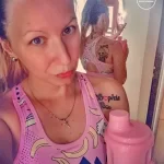 Фото девушки с татуировками на руках и спине, держащей розовую бутылку. Видны изображения животных и надпись "Sophia".