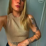 Фото тату на предплечье и руке с изображением ворона и римских цифр. Черно-красная цветовая гамма, детальная проработка перьев и цифр.
