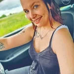 Фотография девушки с татуировкой в виде птицы и цветов на руке. Черно-белое изображение подчеркивает деликатность и изящество рисунка.