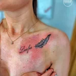 Фото тату: черная татуировка с надписью "Live free" и изображением пера, расположенная на ключице. Минималистичный эскиз татуировки.