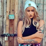 Фото татуировки в виде рукава на руке девушки. Изображены цветы, животные и абстрактные узоры, выполненные в ярких цветах.