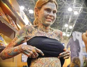 Фото женщины с полностью покрытым татуировками телом. Разнообразные рисунки, яркие цвета, экстремальный боди-арт. Пример максимальной самовыражения через татуировки.