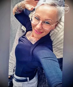 Фото татуировки с цветами на плече девушки. Изображение выполнено в мягких пастельных тонах, с детальной проработкой лепестков и листьев.