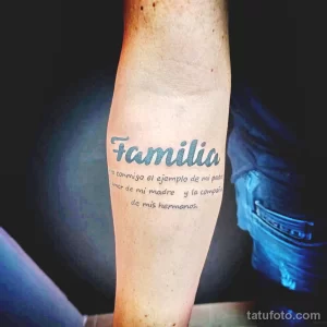 Фото тату на предплечье: Надпись 'Familia' выполненная черными чернилами. Минималистичный рисунок татуировки с красивым шрифтом.