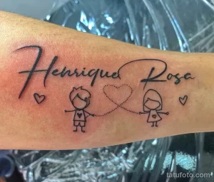 Фото татуировки на руке с написанными именами "Henrique" и "Rosa", соединенными двумя сердцами. Тату выполнено в каллиграфическом стиле.