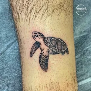 Фото тату маленькой черепахи, выполненной в технике blackwork на руке. Простой и лаконичный рисунок татуировки.