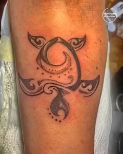 Фото тату черепахи в стиле blackwork на руке. Использование только черного цвета, геометрические формы и точечные узоры.