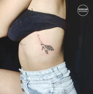 Фото тату: изящная татуировка морской черепахи в технике blackwork на боку. Детализированный рисунок с пузырьками воздуха.