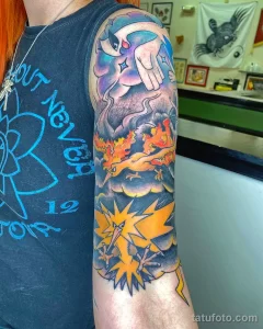 Фотография татуировки на руке с изображением покемонов Charizard, Articuno и Pikachu, выполненной в ярких цветах.