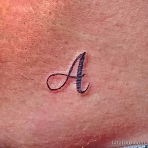 Фото минималистичной татуировки с изображением буквы 'A' на коже. Простой и элегантный дизайн.