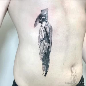 Фото тату: эффектная татуировка гейши в стиле blackwork, выполненная на боку. Контрастные тени и четкие линии создают драматичный образ.