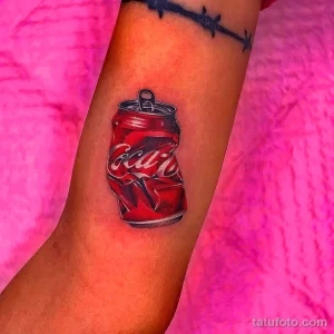 Фото реалистичной татуировки банки Coca-Cola на руке. Детализированное изображение, отражения света, эффект открытой банки.