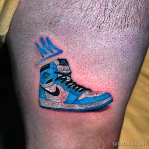 Фото тату кроссовок Nike Air Jordan на бедре. Реалистичный рисунок, яркие цвета, детализированная проработка татуировки.
