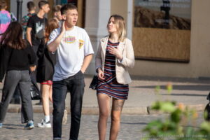 Фотография уличной татуировки на внутренней стороне бедра девушки в летнем платье. Видна детальная проработка рисунка.
