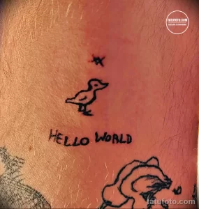 Фото тату с изображением маленькой птички и надписи "Hello World", выполненной в минималистичном стиле на коже. Простой рисунок татуировки.