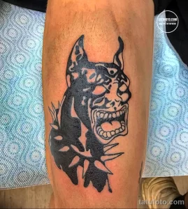 Черно-белое тату на руке с изображением маски Они в стиле blackwork. Геометрические узоры, плотная штриховка, японская тематика.