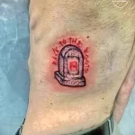 Фото тату на руке с изображением красного портала, в центре которого находится глаз. Надпись вокруг портала на неизвестном языке. Мистический рисунок татуировки.