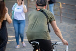 Фото мужчины на велосипеде с небольшой татуировкой на руке. Татуировка выполнена в минималистичном стиле черными чернилами.