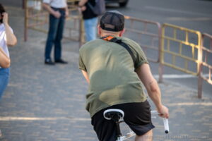 Фото мужчины на велосипеде с небольшой татуировкой на руке. Татуировка выполнена в минималистичном стиле.