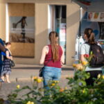 Фото татуировки на спине девушки, выполненной в технике лайнуорк. Изящный рисунок подчеркивает красоту тела и создает легкий летний образ.