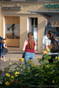 Фото татуировки на спине девушки, выполненной в технике лайнуорк. Изящный рисунок подчеркивает красоту тела и создает легкий летний образ.