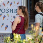 Фото тату на плече девушки, выполненное в минималистичном стиле. Изящный рисунок дополняет летний образ и подчеркивает красоту кожи.