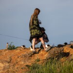 и женщина с большим количеством татуировок любуются морем со скалыби - Уличная тату 22062022 №113 - tatufoto.com