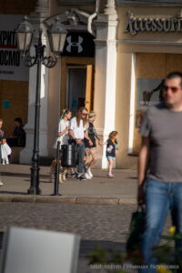 Фотография группы людей с татуировками, идущих по улице. Видны тату на руках и ногах, выполненные в различных стилях.