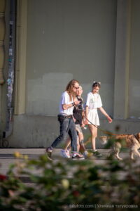 Фотография трех людей с татуировками, идущих по улице. Видны тату на руках и ногах, выполненные в различных стилях.