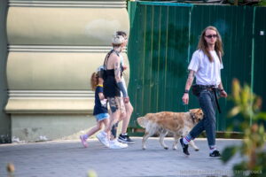 Фото тату: женщина с татуировками на руке и ноге, гуляющая с мужчиной и собакой. Разнообразные рисунки татуировок, вдохновляющие идеи для тату.