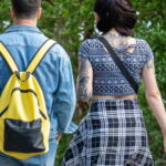 Фото тату на спине девушки. Черно-белый геометрический узор, напоминающий кружево, покрывает верхнюю часть спины, переходя на плечи. Стиль татуировки - геометрия.