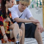 молодая девушка с татуировкой сюжетом из японского аниме на ноге01 - Уличная тату 22062022 №209 - tatufoto.com