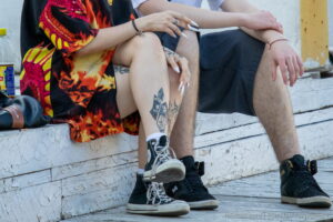 Фото тату на бедре: стилизованный портрет лица, заключенный в геометрические фигуры, выполненный в черных тонах, на фоне кожи.