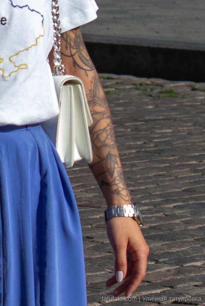 молодая девушка с татуировкой цветов на левой руке15 - Уличная тату 22062022 №217 - tatufoto.com