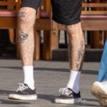 молодой парень с татуировками надписями на коленях ни шагу назад - только вперёд04 - Уличная тату 22062022 №281 - tatufoto.com