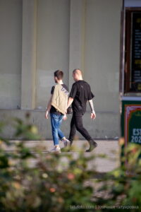 Фото двух мужчин, один из которых имеет татуированные рукава в стиле реализм и графика. Современный городской стиль.