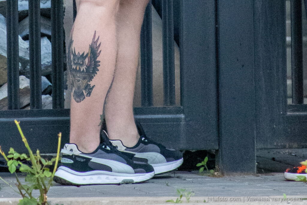 молодой парень с татуировкой сова с глазом в треугольнике внизу правой ноги32 - Уличная тату 22062022 №320 - tatufoto.com