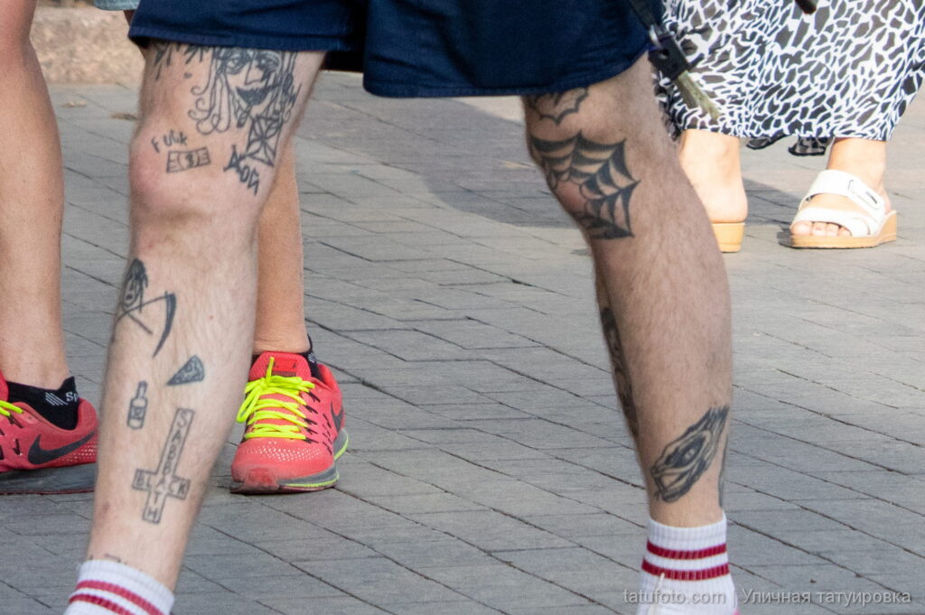 молодой парень с хэндпоук татуировками Паутина и перевёрнутый крест на ноге03 - Уличная тату 22062022 №324 - tatufoto.com