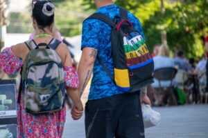 Фото татуировки на руке мужчины: черные иероглифы и надпись, выполненные в минималистичном стиле. Изображение сделано на улице, в движении.