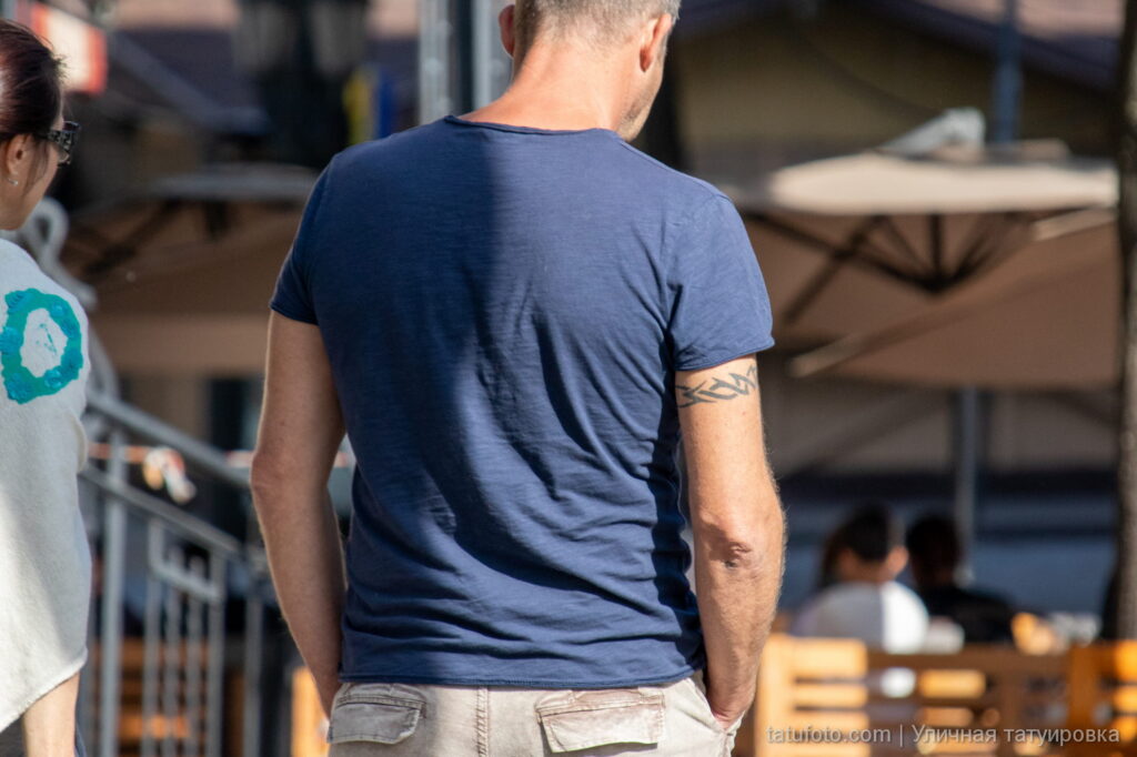 мужчина с татуировкой браслетом трайбл узоры в верхней части руки42 - Уличная тату 22062022 №482 - tatufoto.com