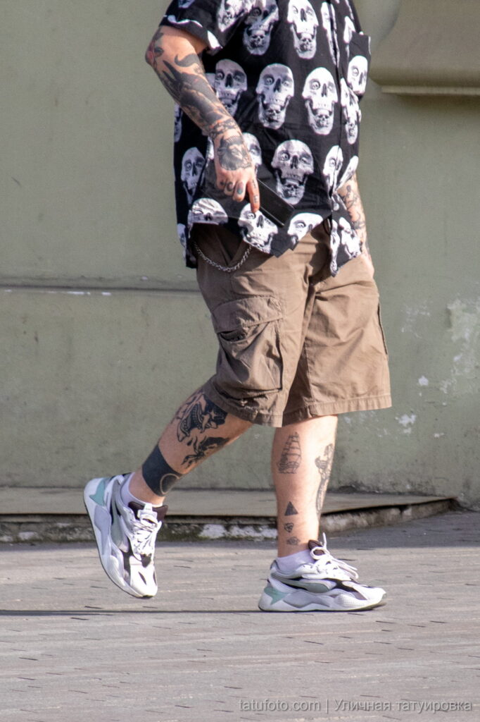 мужчина с татуировкой чёрного сердца и парусником внизу ног35 - Уличная тату 22062022 №566 - tatufoto.com