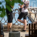 Фото тату на спине мужчины: красочный рисунок в японском стиле с изображением карпа кои, цветов и волн. Детализированная проработка и яркие цвета.